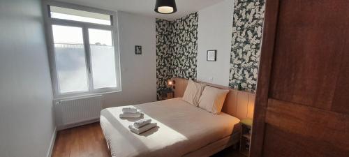 a small bedroom with a bed with two towels on it at Jolie Maison 3 chb- 7 lits- jardin in Levroux