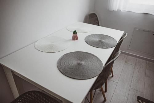 a white table with three plates on top of it at Lake View Apartment Iasi in Valea Lupului
