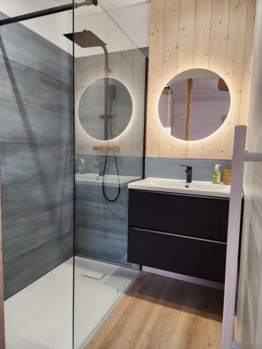 une salle de bain avec une douche, un lavabo et un miroir dans l'établissement Au Bon Endroit, à Salles