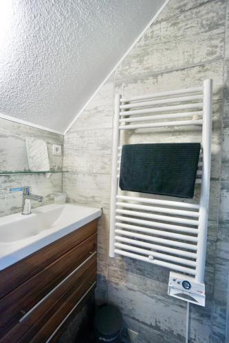 La salle de bains est pourvue d'un lavabo et d'une fenêtre avec une serviette. dans l'établissement L'épicurien - Front de mer -, à Ploemeur