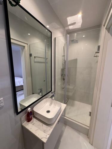 a white bathroom with a sink and a shower at Peartree Homes in Lagos