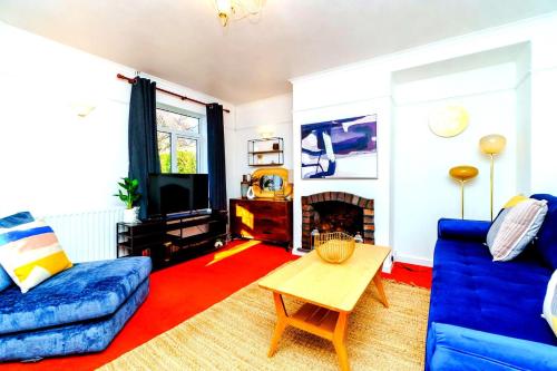 a living room with a blue couch and a fireplace at Spacious 4-Bed Bristol | WiFi | Parking | Workspace in Bristol