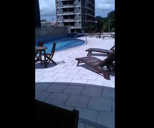 un patio con mesas y sillas y una piscina en Ajuricaba Suites 6, en Manaus