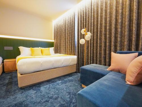 a hotel room with two beds and a couch at The GALA Hotel Umeda in Osaka