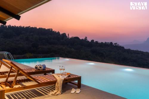a pool at a resort with a view of the mountains at StayVista at Chitrakoot with Pool & Lawn in Kolvan