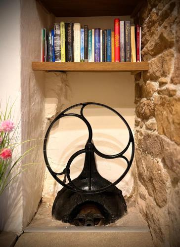 a black fan is sitting in a book shelf at Murphys Thatched Cottage in Mitchelstown