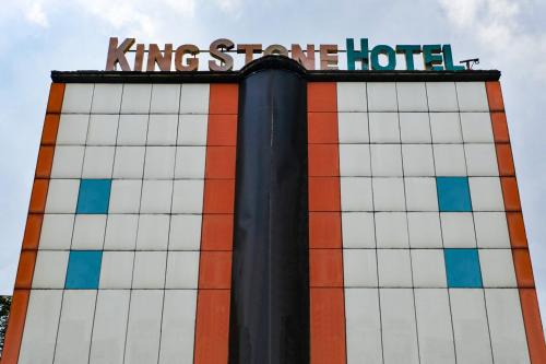 a building with a hotel sign on top of it at King Stone Hotel in Mencil