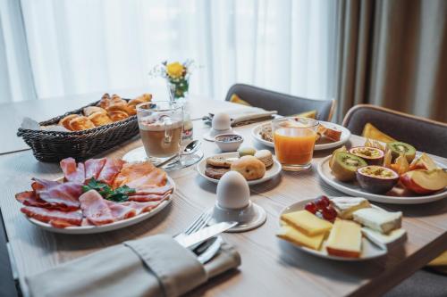 a table topped with plates of food and drinks at Mercure Hotel Delémont in Delémont