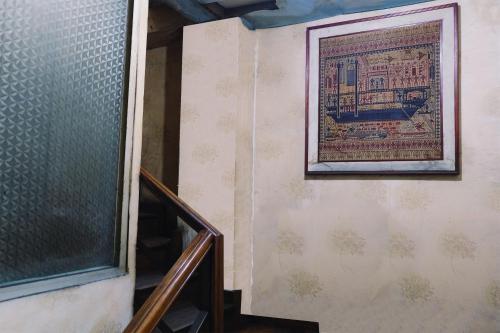 a painting on a wall next to a stairway at King Stone Hotel in Mencil