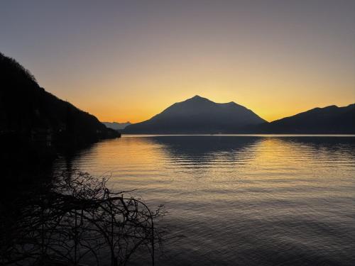 a sunset over a lake with mountains in the background at Villa Rêverie - Boutique Hotel in Bellano