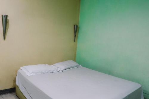 a small bedroom with a white bed in a room at King Stone Hotel in Mencil