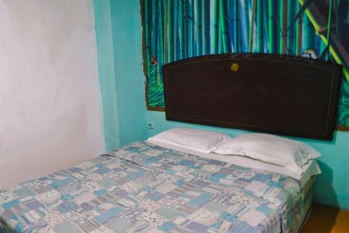 a bedroom with a bed with a blue wall at King Stone Hotel in Mencil