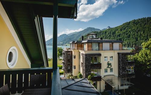 a balcony of a building with a view of a lake at Seehotel Brandauer's Villen in Strobl
