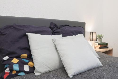 - un ensemble d'oreillers assis au-dessus d'un lit dans l'établissement Le Coquet, bord de l'eau, à Mulhouse