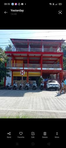 a red building with motorcycles parked in front of it at Talisay Inn in Anda