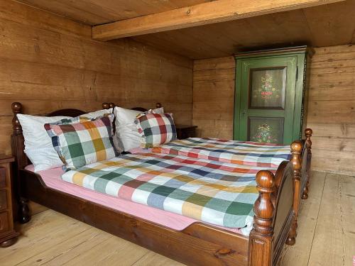 a bedroom with a bed in a log cabin at Gemütliches Chalet-Zimmer in Farmhouse Rosalie in Brunnadern