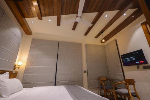 a bedroom with a bed and a tv on the wall at Narayana Homes in Mathura