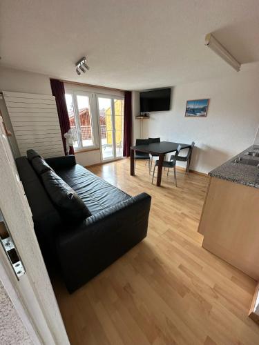 a living room with a black couch and a table at Royal Swiss Apartments in Ringgenberg
