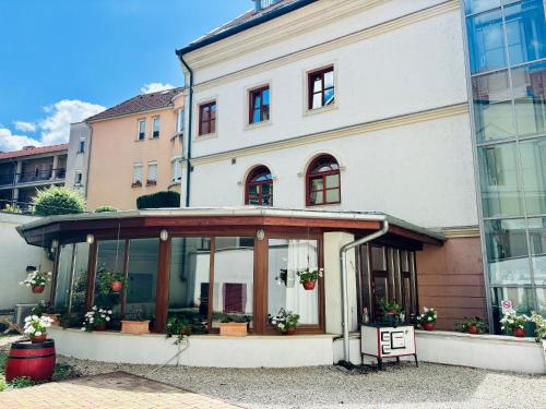 a large white building with windows and plants at A Bárány in Kaposvár