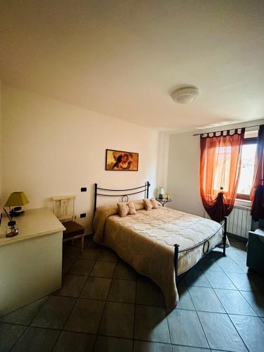 a bedroom with a bed and a desk and a window at Agriturismo La Fattoria in Norcia