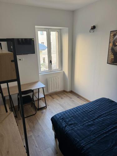 une chambre avec un lit, un bureau et une fenêtre dans l'établissement Escapade savoyarde, à Chambéry