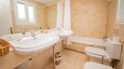a bathroom with two sinks and a toilet at Villas del Golf 27 in Manilva