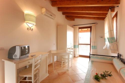 a living room with a table and a tv on a desk at Gallura style Res Baia Del Mirti B4 1BedAp sleeps4 in Vignola Mare