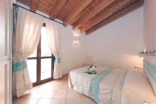 a bedroom with a bed and a large window at Gallura style Res Baia Del Mirti B4 1BedAp sleeps4 in Vignola Mare