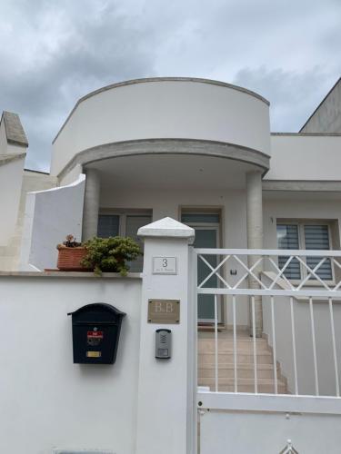 a house with a white fence and a gate at B&B Passione Salento in Surbo