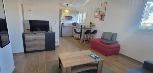 un salon avec un canapé rouge et une table dans l'établissement Charming studio near the beaches in Saint-Raphaël, à Saint-Raphaël