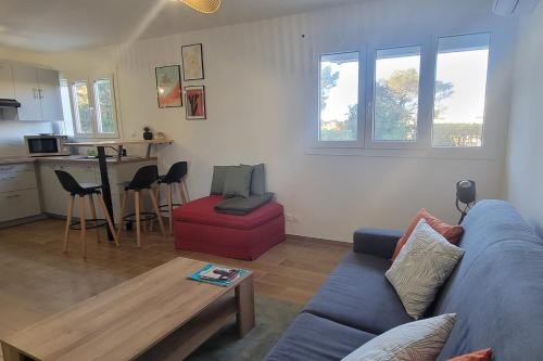 un salon avec un canapé bleu et une table dans l'établissement Charming studio near the beaches in Saint-Raphaël, à Saint-Raphaël