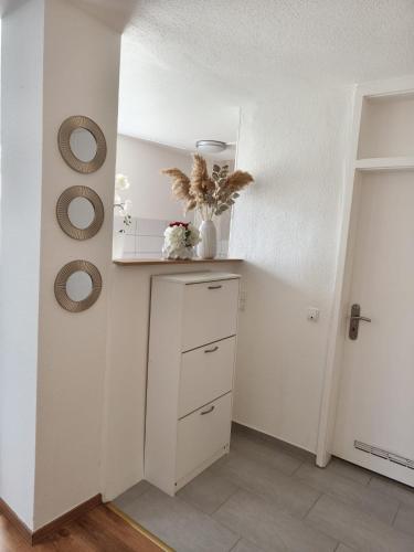 a white room with a shelf and a vase with flowers at Ferienwohnung Antonia in Bad Neuenahr-Ahrweiler