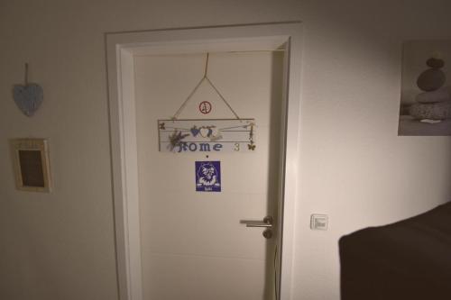 una porta con un cartello di casa sopra di Ferienwohnung Spitz a Dornum