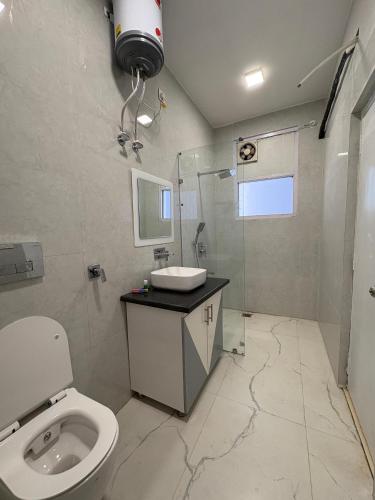 a bathroom with a toilet and a shower and a sink at JD Heritage Inn in Bareilly