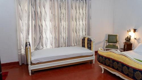 a bedroom with a bed and a window with curtains at Monticello Bungalow in Kotmale