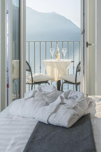 a blanket on a bed in a room with a table at Villa Rêverie - Boutique Hotel in Bellano