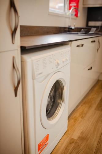 a white washer and dryer in a kitchen at Cozy and stylish 2 bedroom home in Leicester