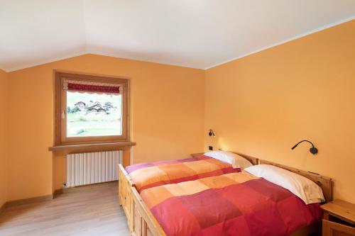 Un dormitorio con una cama y una ventana en Appartamento Legnameir Bait da Rez, en Livigno
