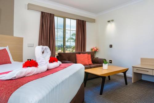 a hotel room with a bed and a couch at Hamilton's Queanbeyan Motel in Queanbeyan