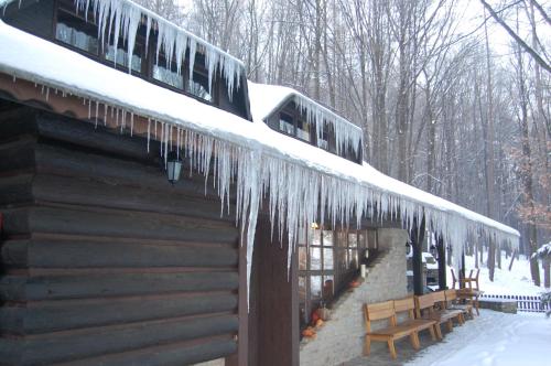 a log cabin with icicles hanging from the roof at Koliba u Cerneho Medveda in Zlín