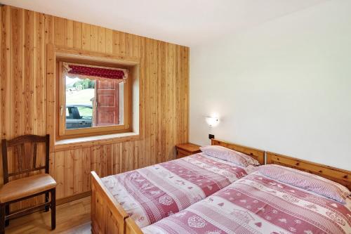 a bedroom with a bed and a window at Appartamento Pizalegn Bait da Rez in Livigno