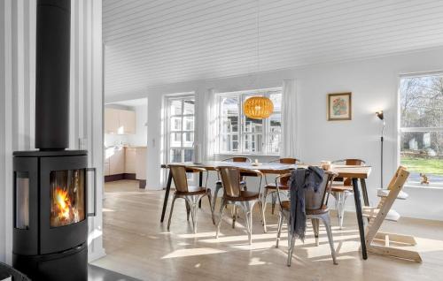 a dining room with a fireplace and a table and chairs at Beach Front Home In Bogense With Wifi in Bogense