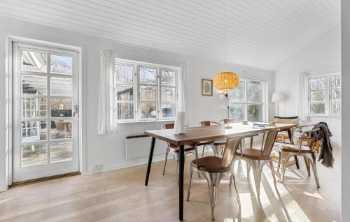 a dining room with a table and chairs and windows at Beach Front Home In Bogense With Wifi in Bogense