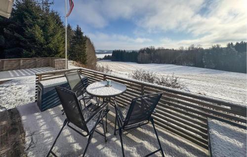 a patio with a table and chairs on a snow covered deck at 2 Bedroom Lovely Home In Enebakk in Sand