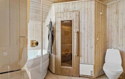 a bathroom with a tub and a toilet and a sink at Gorgeous Home In Juelsminde With Sauna in Sønderby