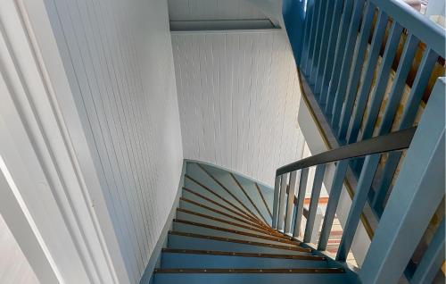 a spiral staircase with blue railings in a house at Gorgeous Home In Åheim in Åheim