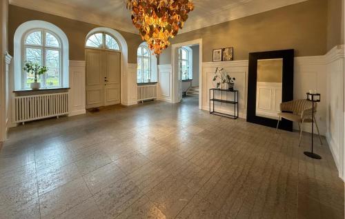 a large room with a chandelier and a room with a table and chairs at Nice Home In Ekeby With Wifi in Ekeby