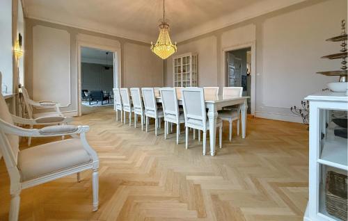 a dining room with a table and white chairs at Nice Home In Ekeby With Wifi in Ekeby