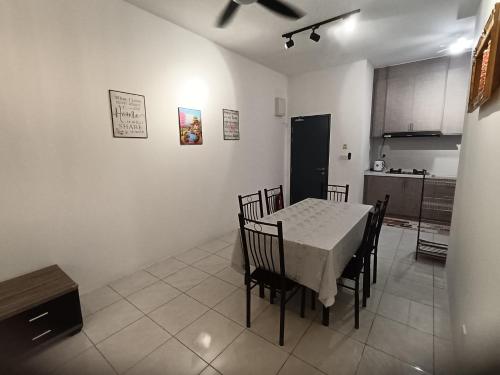 a kitchen with a table and chairs in a room at Naanee Homestay near Putrajaya Cyberjaya - musleem only in Kampung Dengkil