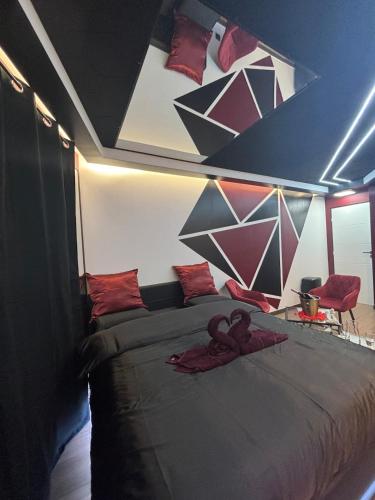 une chambre avec un grand lit avec des oreillers rouges dans l'établissement Love Room Redroom, à Voiron